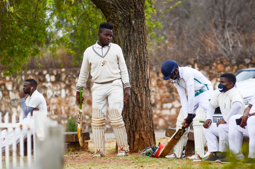Cricket players in coordinated sports uniforms preparing for a match
