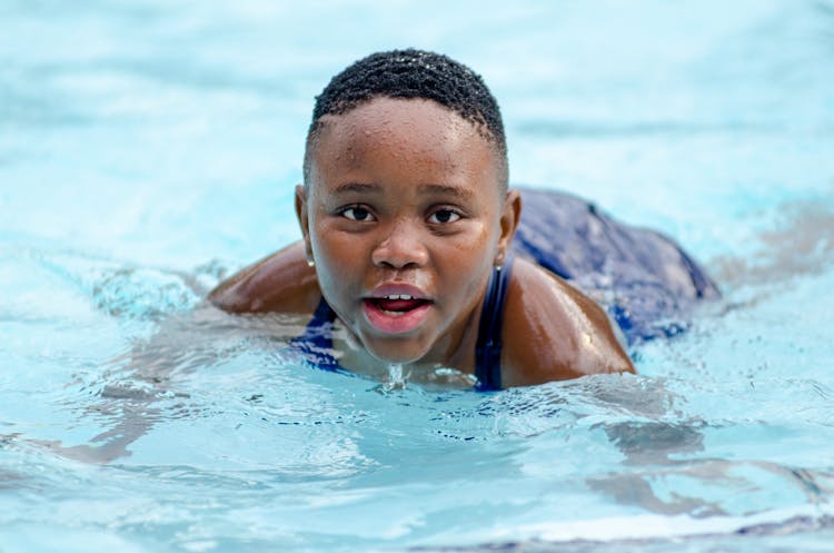 Kid Swimming In Pool