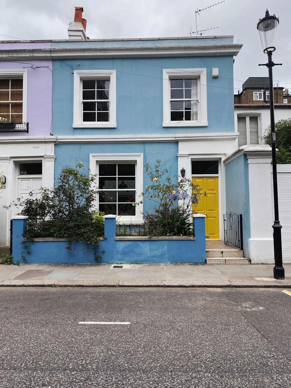 Blue terraced house with yellow door in London