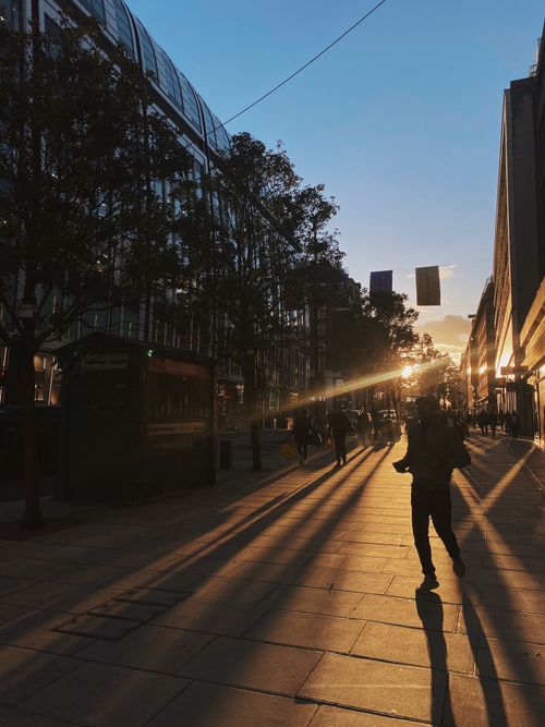 Free Silhouettes of people walking at sunset on a busy London street. Stock Photo