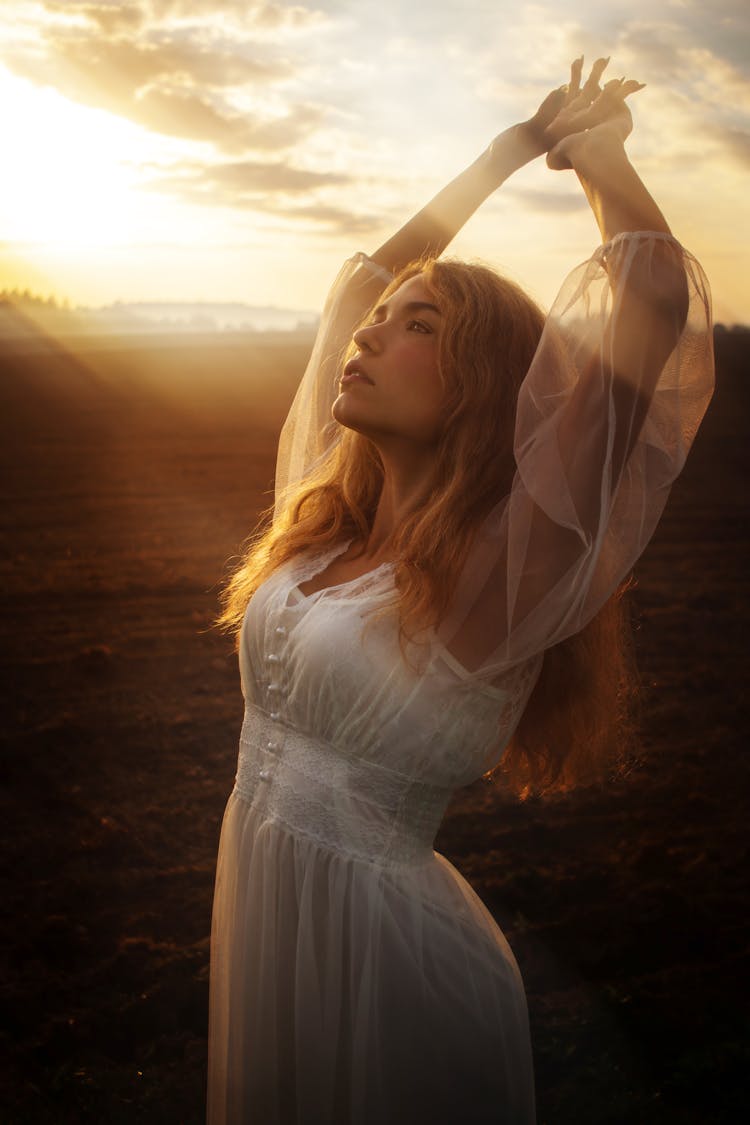 Woman Posing With Raised Arms In Field