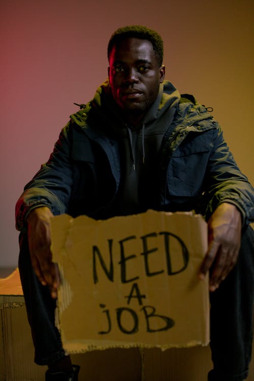 Free Sitting homeless man holding cardboard Stock Photo