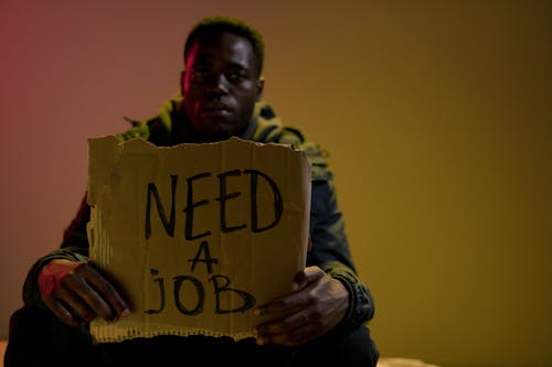 Sitting homeless man holding cardboard