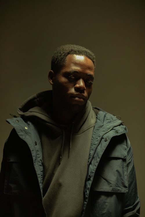 Free A thoughtful man in a hoodie and jacket, captured indoors with dramatic lighting. Stock Photo