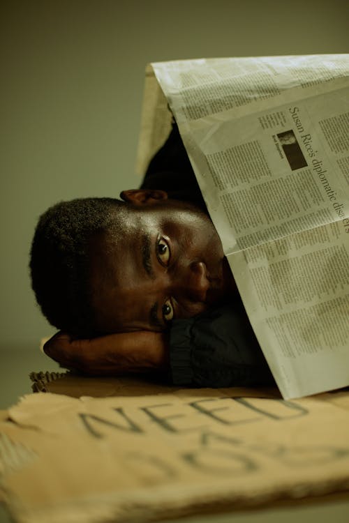 Workless man lying on side on cardboard