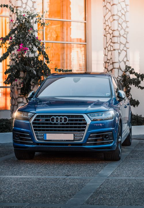 Free Shiny blue luxury sedan parked on stone pavement with scenic background. Stock Photo
