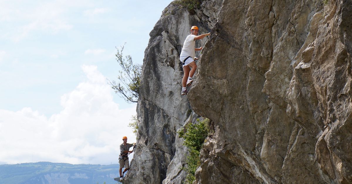 student climbing a mountain or taking a risk outdoors, smiling