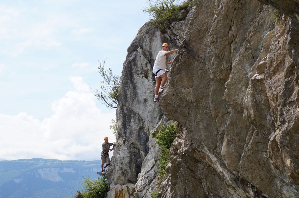 Two climbers ascending a rugged cliff