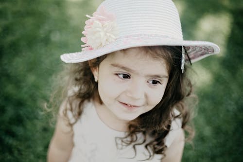 Free A Cute Young Girl Smiling while Wearing a Hat Stock Photo