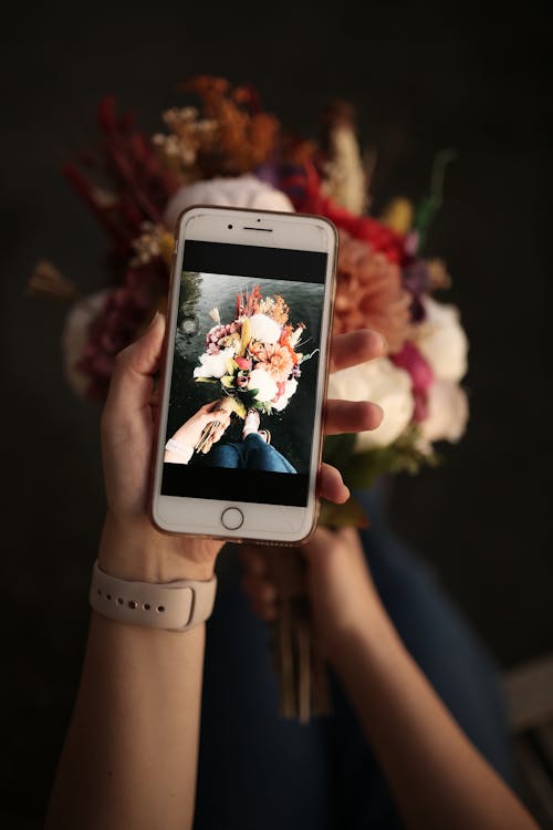 Person Holding a Silver Iphone 