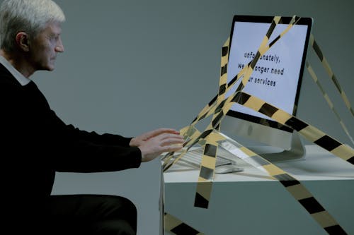Free Man typing on computer which is tied with a tape Stock Photo