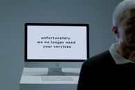 Part of a body of an elderly man and behind screen with information that he is not needed anymore