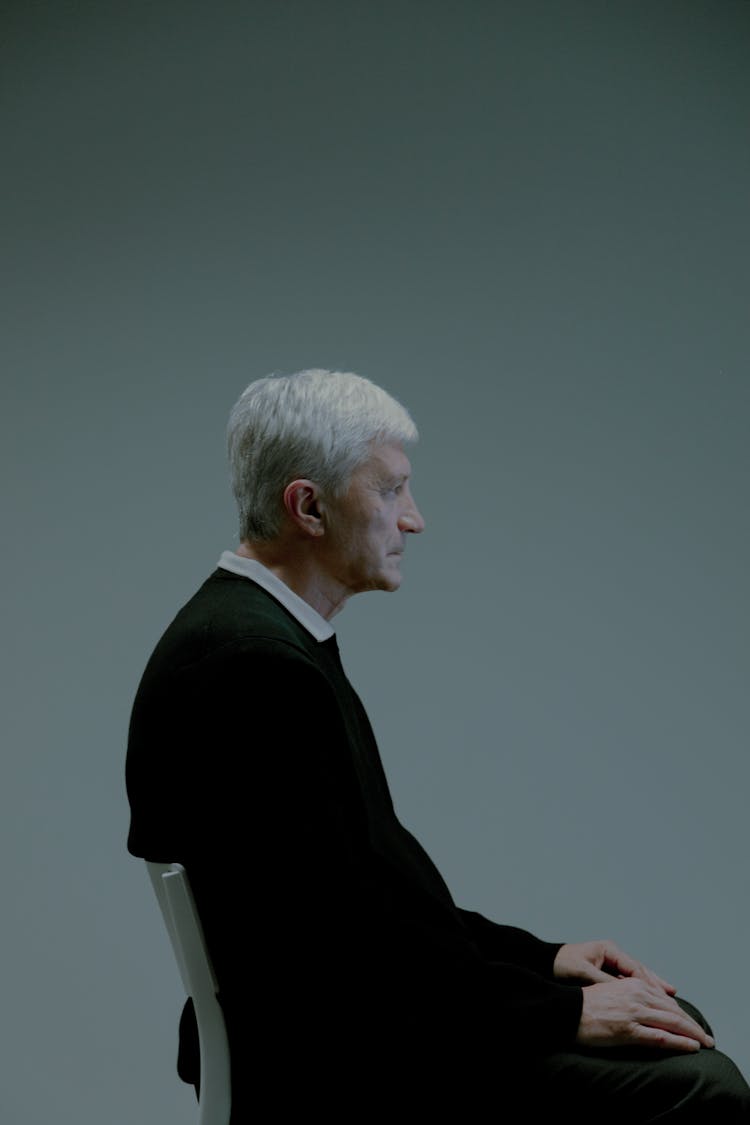 Profile Of An Elderly Man Sitting On A Chair