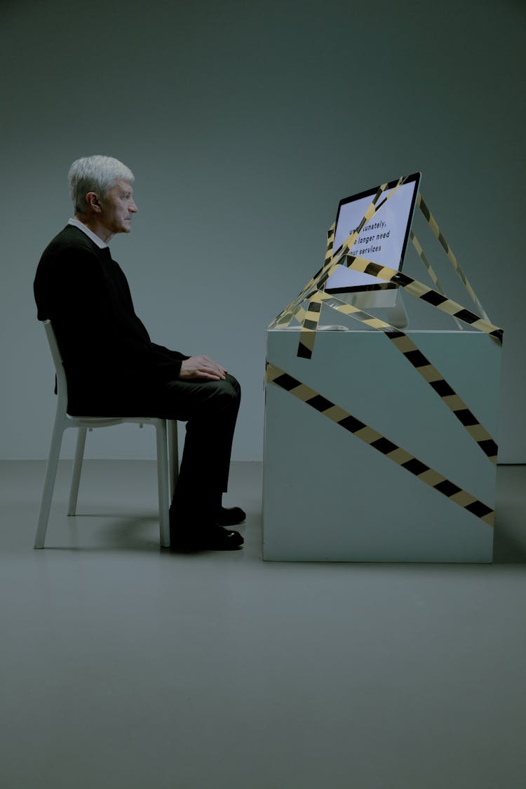 Elderly Man Sitting In Front Of A Computer