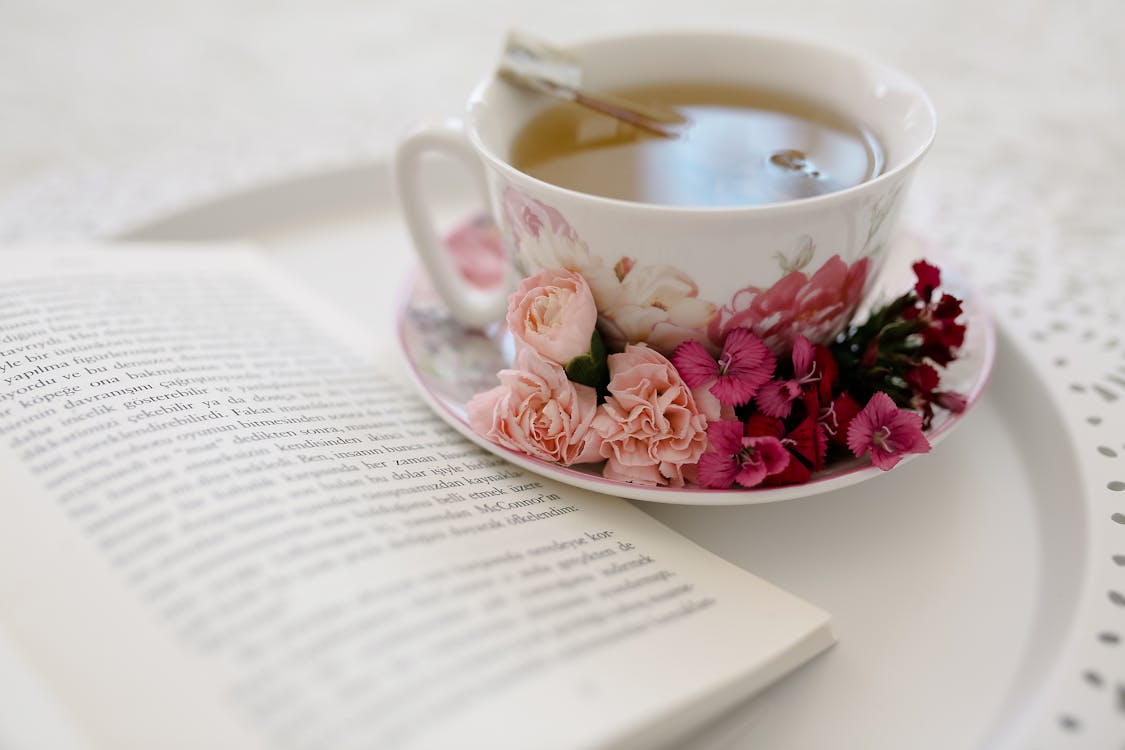 Close-up of tea, flowers and book