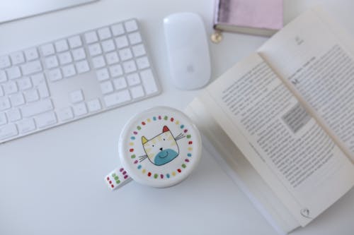 Mug by a Book and a Keyboard on a Desk