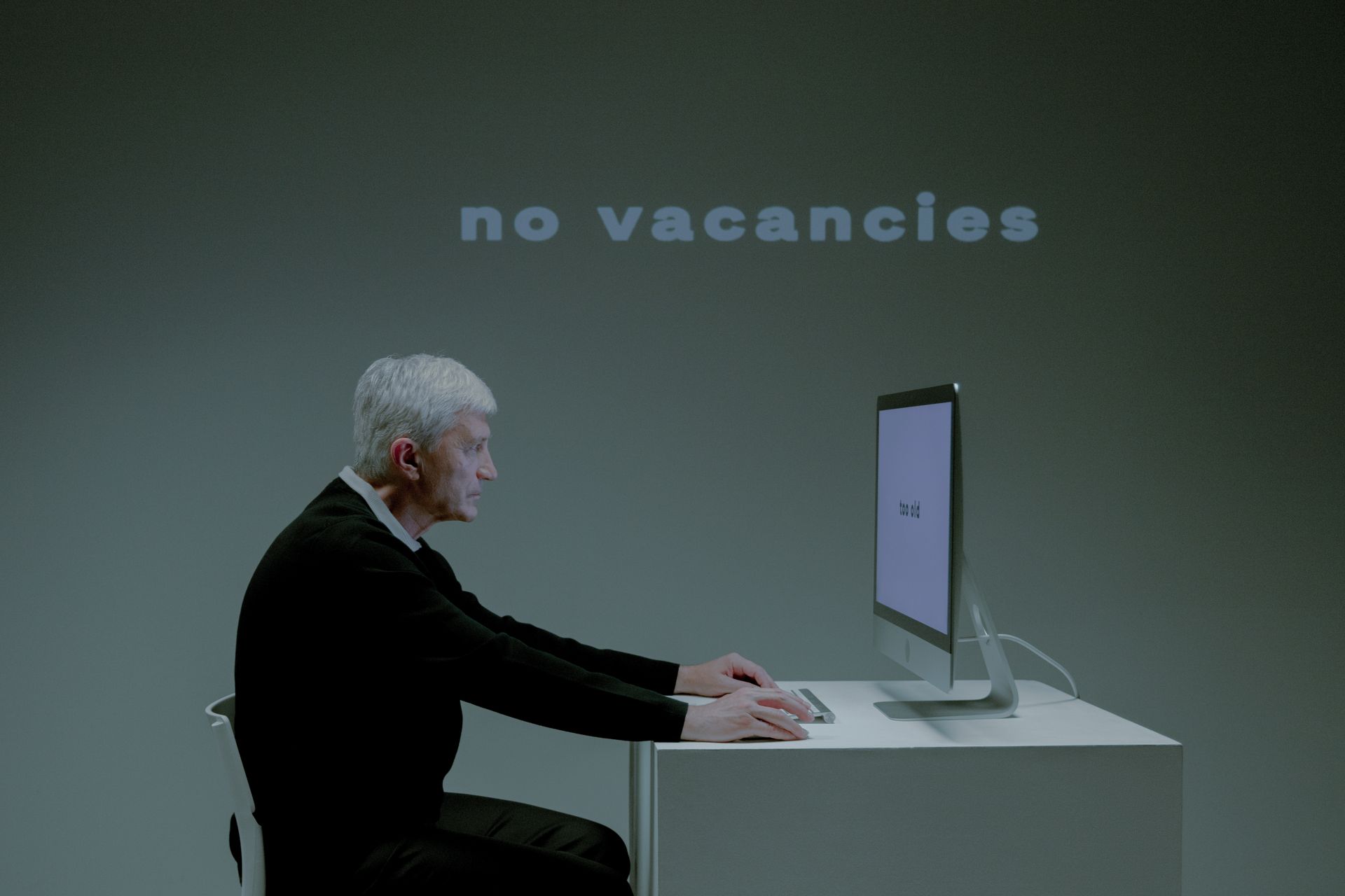 An Elderly Man with a Serious Face while using a Computer