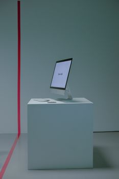 PC with glowing screen standing on podium behind red line
