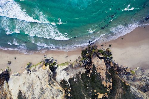 Free A stunning aerial view of Portugal's coastline with turquoise waters and rugged rocks. Stock Photo