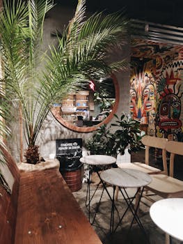 Trendy cafe interior featuring vibrant graffiti art, wooden furniture, and lush potted plants creating a lively atmosphere.