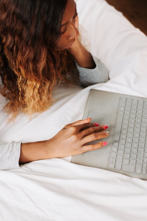 Free Woman using laptop in bed Stock Photo