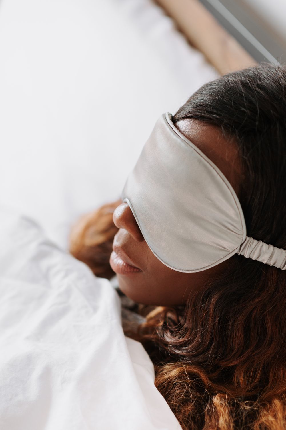 Woman lying down wearing a sleep mask for restful sleep