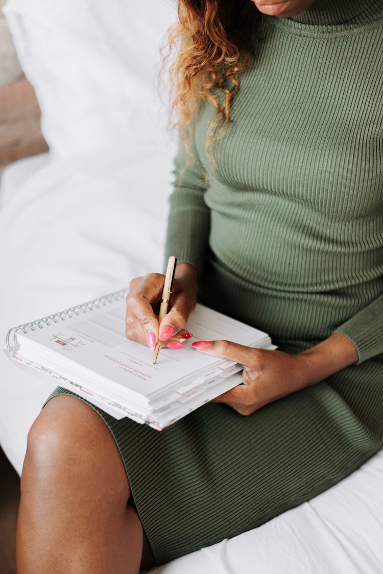 Woman On Bed Writing In Notebook