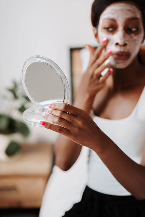 Free Woman applying face mask in bedroom Stock Photo