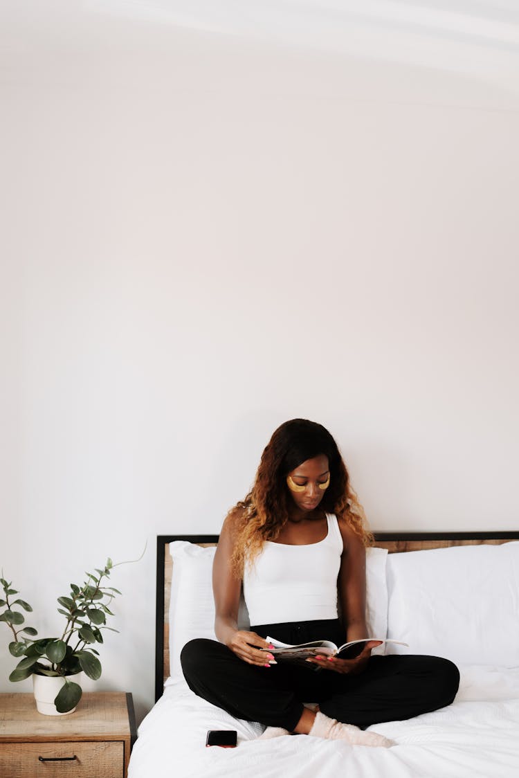 Woman Reading Magazine In Bed