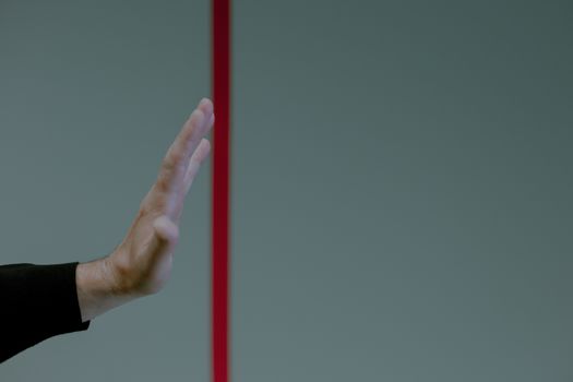 Studio shot of hand behind red line