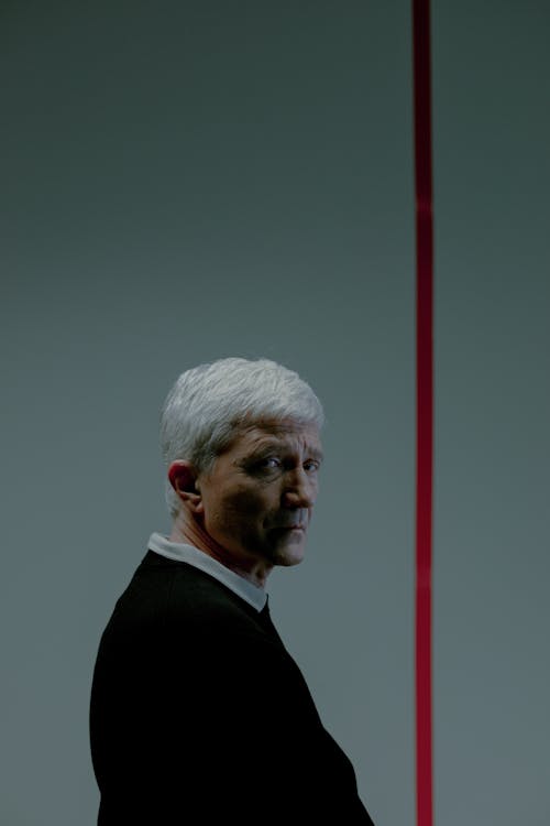 Man with gray hair behind red line