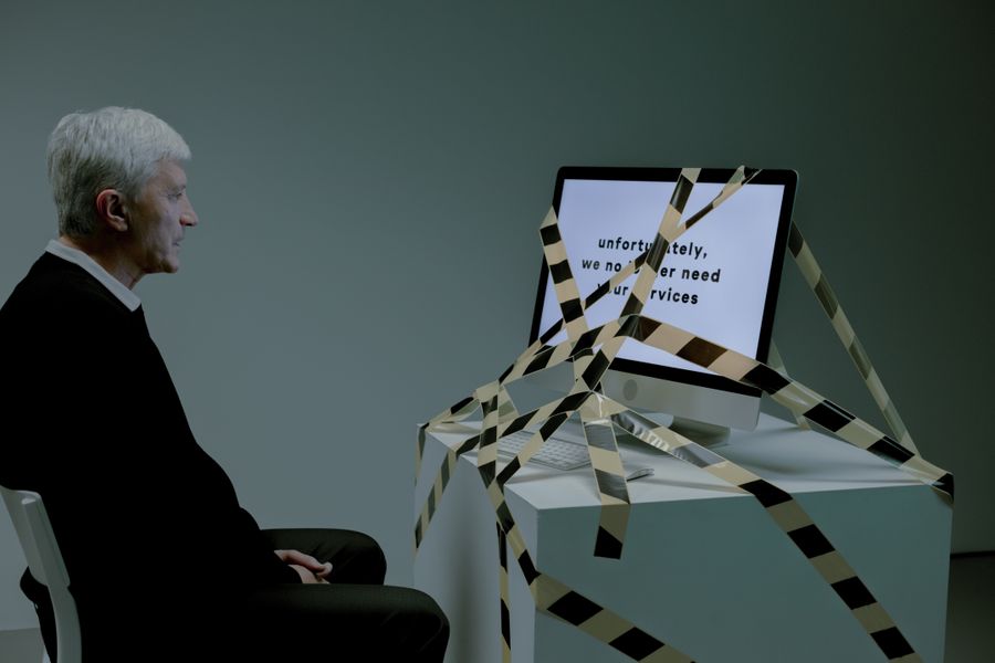 Older worker facing a job loss at a computer