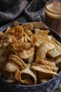 Spicy chips in blue bowl standing next to glass of coffee
