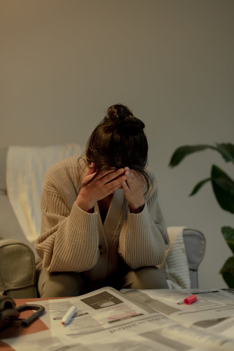 Portrait Of Unemployed Woman With Head In Hands