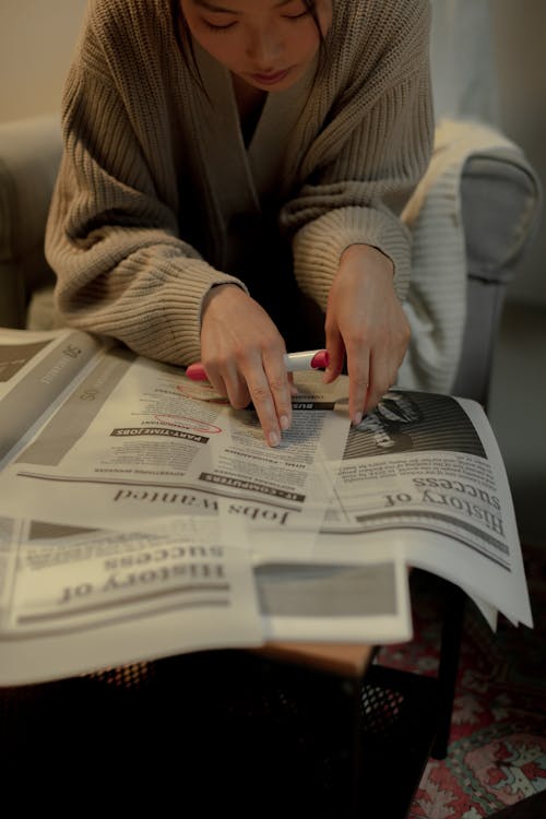 Free Sitting woman looking for job in newspaper Stock Photo