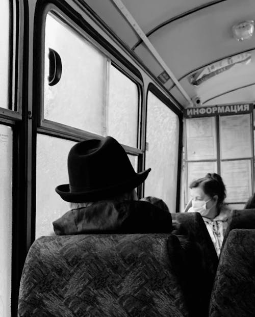 Grayscale Photo of Man in Cowboy Hat Sitting on Train