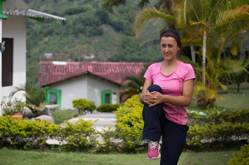 A Woman in Pink Shirt Stretching Her Legs