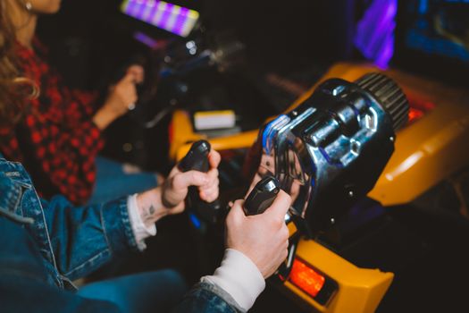 People enjoying a thrilling virtual reality driving simulation in a vibrant arcade setting.