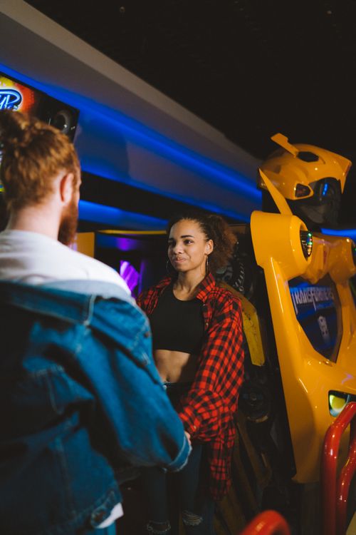 Free A couple enjoying a fun time together at an arcade surrounded by colorful machines. Stock Photo