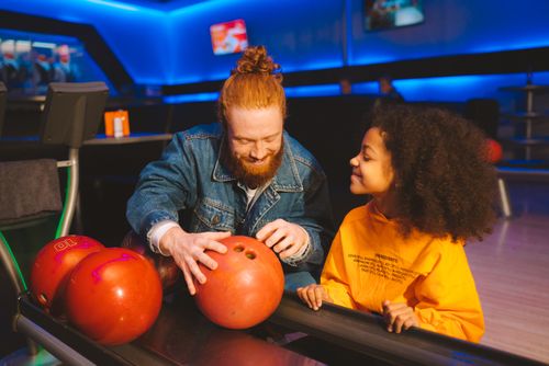 Free Father and daughter enjoying a fun day together at the bowling alley. Stock Photo