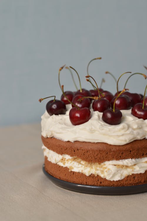 A Cake with Whipped Cream and Cherries on Top