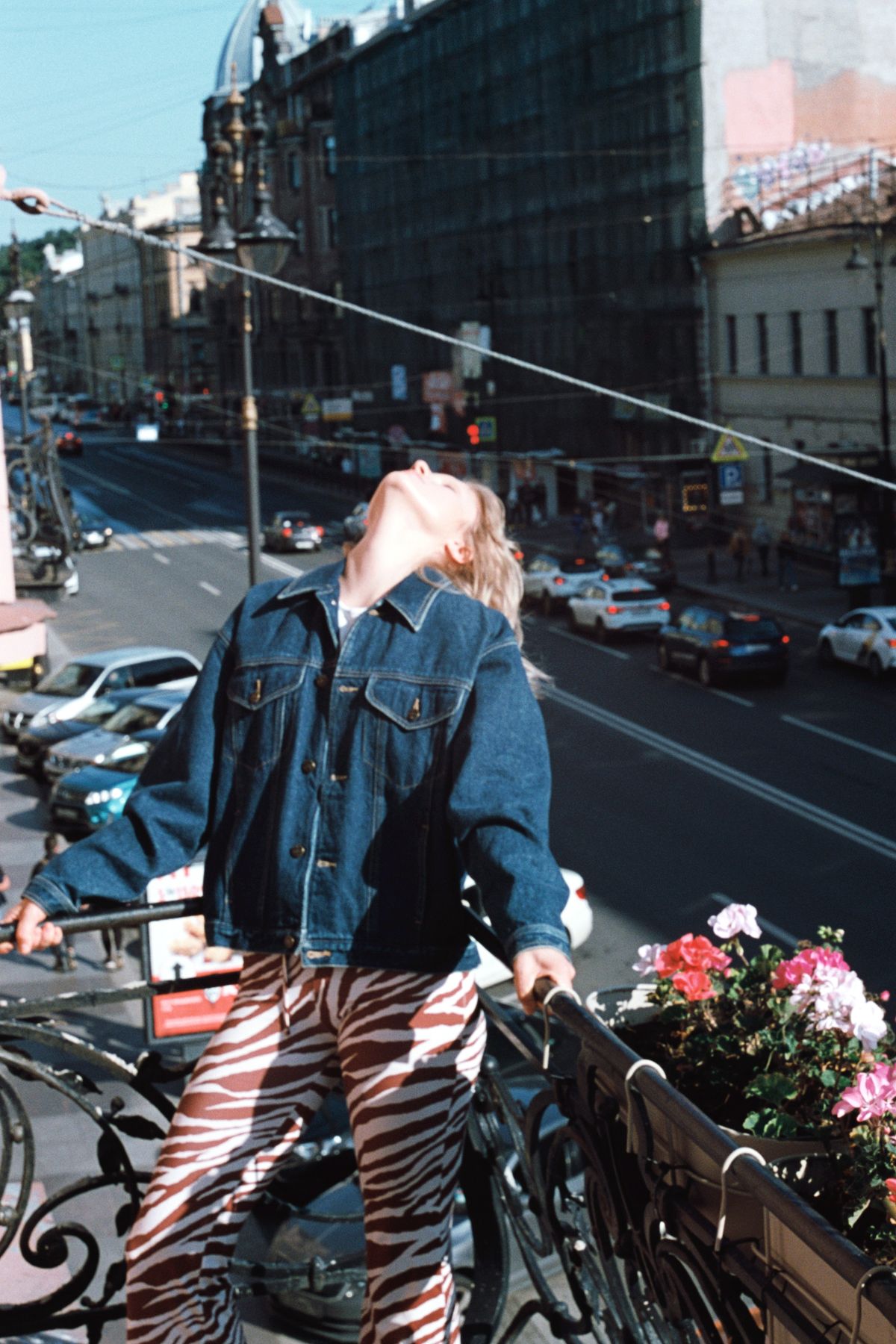 A woman in a denim jacket leaning on a railing — the refined denim jacket