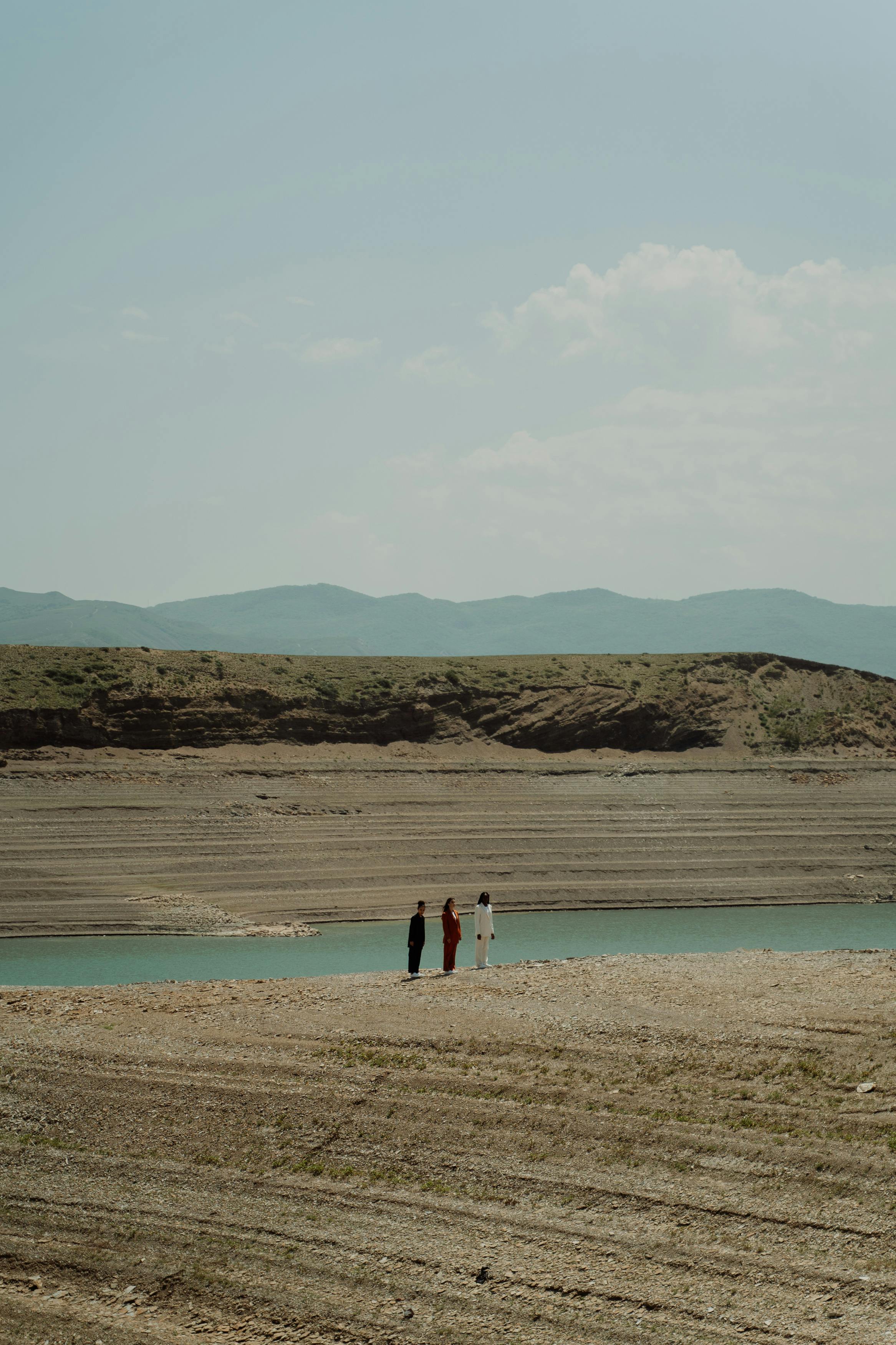 people standing near a body of water in distance