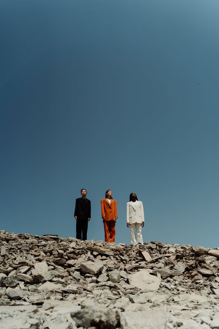 Three Women Standing On Rocky Ground