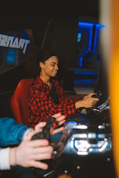 Woman in checkered shirt having fun playing an arcade racing game, smiling and engaging.