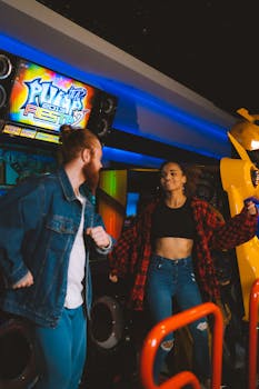 A joyful young couple playing a dance arcade game at an indoor entertainment center, showcasing fun and leisure.