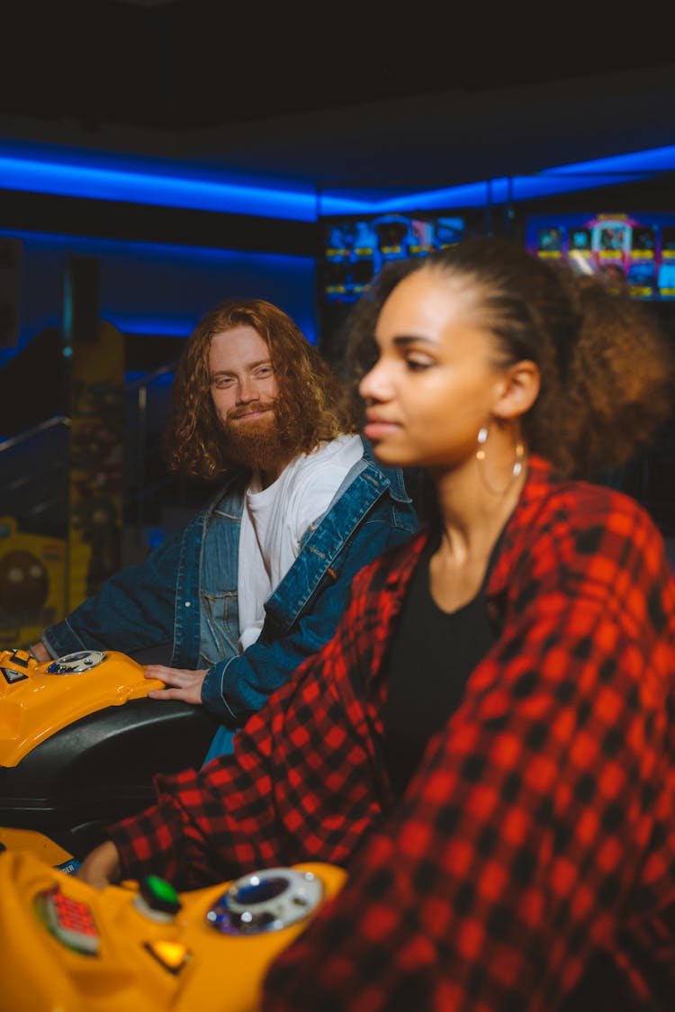 Couple Playing On Machines In A Club