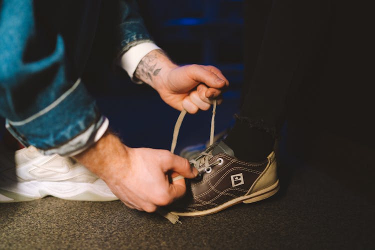 A Person Tying A Shoelace