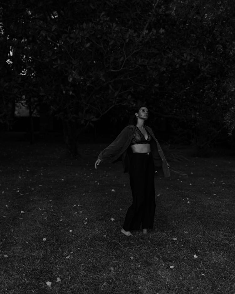 Black And White Photo Of Woman Dancing In Forest At Night