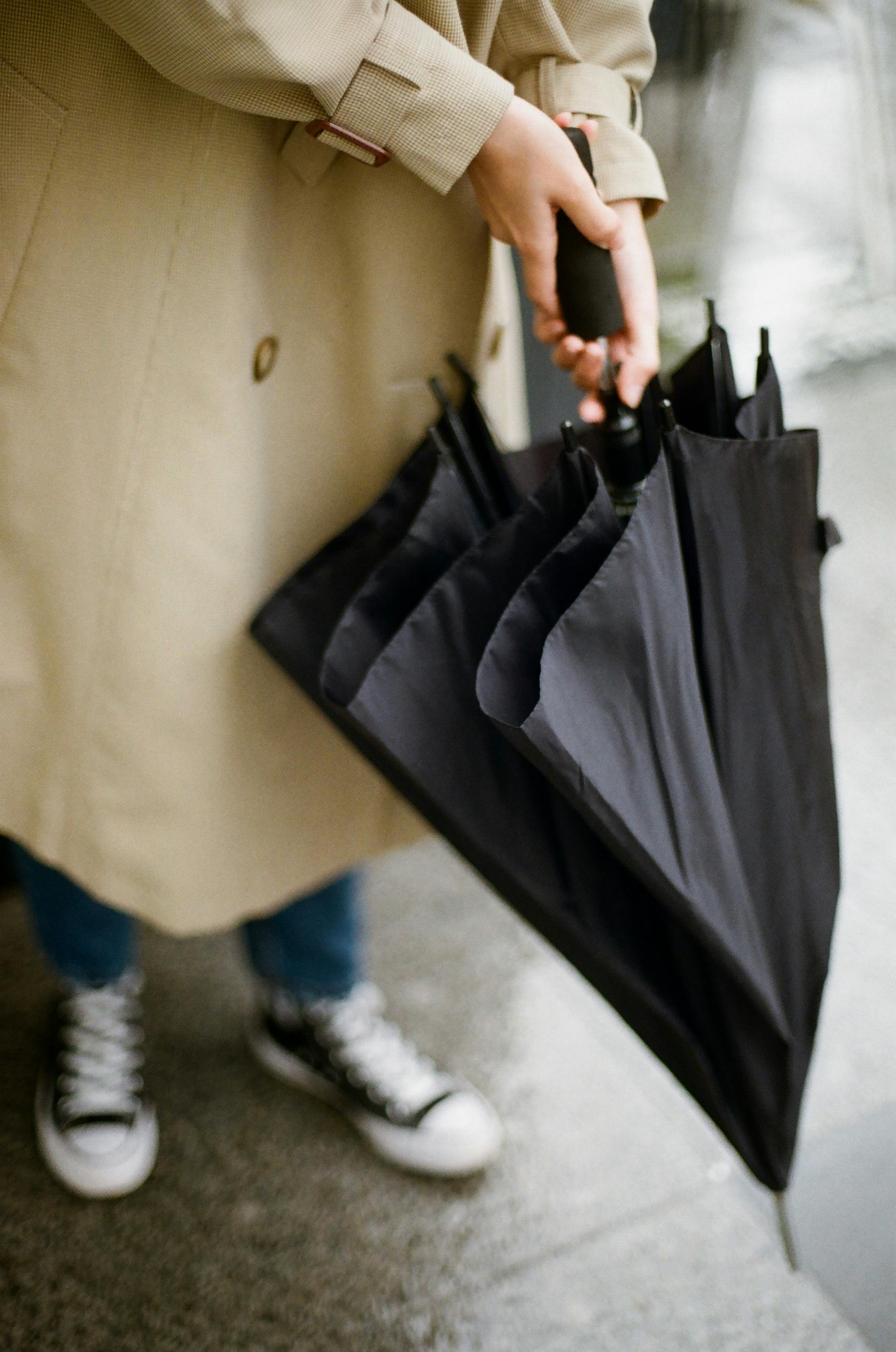 unrecognizable hands opening black umbrella